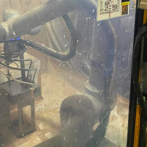 Industrial robot covered in dust and powder buildup